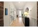Inviting hallway featuring a tiled floor and light walls with a decorative black console table at 7912 Yale Harbor Dr, Wesley Chapel, FL 33545