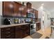 Modern kitchen featuring granite countertops, stainless steel appliances, and dark wood cabinetry at 7912 Yale Harbor Dr, Wesley Chapel, FL 33545