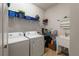 Convenient laundry room with washer, dryer, utility sink, and storage shelves at 7912 Yale Harbor Dr, Wesley Chapel, FL 33545