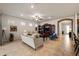 Bright living room with tile floors, ceiling fan, and large windows, connected to kitchen through brick archway at 7912 Yale Harbor Dr, Wesley Chapel, FL 33545