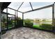 Enclosed patio featuring tile flooring and views of the backyard and a tranquil lake at 7912 Yale Harbor Dr, Wesley Chapel, FL 33545