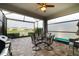 Screened in patio featuring a table and chairs overlooking the lake and surrounding neighborhood at 7912 Yale Harbor Dr, Wesley Chapel, FL 33545