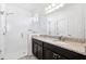 Bathroom featuring a glass shower, dark cabinets, and double sinks at 8496 Starlight Loop, Parrish, FL 34219