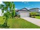Well-maintained home exterior with a lush green lawn and a two-car garage at 8496 Starlight Loop, Parrish, FL 34219