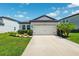Charming single-story home featuring a manicured lawn, complemented by a 2-car garage and a classic gray exterior at 8496 Starlight Loop, Parrish, FL 34219