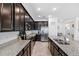 Stylish kitchen with granite countertops, dark cabinets, stainless steel appliances, and a functional open-concept design at 8496 Starlight Loop, Parrish, FL 34219