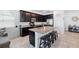 Modern kitchen with a granite island, stainless steel appliances, and sleek, dark cabinetry and bar stool seating at 8496 Starlight Loop, Parrish, FL 34219