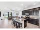 Bright, open kitchen featuring granite island, dark cabinetry, stainless appliances, and seamless integration with the living space at 8496 Starlight Loop, Parrish, FL 34219
