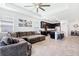 Open concept living and kitchen area with tile flooring, a large sectional sofa and island with seating at 8496 Starlight Loop, Parrish, FL 34219