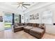 Cozy living room with a large sectional sofa, tile flooring, ample natural light, and views of the backyard and pool at 8496 Starlight Loop, Parrish, FL 34219