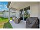 Relaxing covered patio with ceiling fan, comfortable seating and outdoor grill at 8496 Starlight Loop, Parrish, FL 34219