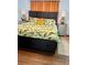 Well-lit bedroom with dark wood bed frame, tropical-patterned bedding, and neutral-toned walls and wood floors at 1020 38Th N Ave, St Petersburg, FL 33704