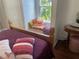This bedroom features a wooden bed frame with decorative red blanket and a window seat at 1020 38Th N Ave, St Petersburg, FL 33704