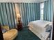 This bedroom features long blue curtains, a queen bed and a chaise lounge chair at 1020 38Th N Ave, St Petersburg, FL 33704