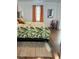 Bright bedroom with a tropical-patterned bedspread, wood floors, and orange curtains for a relaxing atmosphere at 1020 38Th N Ave, St Petersburg, FL 33704