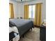 Comfortable bedroom with sunny yellow curtains, wood floors, and a decorative rug at 1020 38Th N Ave, St Petersburg, FL 33704