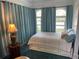 This bedroom features long blue curtains, a queen bed and a side table with a lamp at 1020 38Th N Ave, St Petersburg, FL 33704