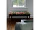 A beautiful floral bench sits in front of a bright window on lovely wood floors at 1020 38Th N Ave, St Petersburg, FL 33704