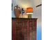 Beautiful rustic red and gold cabinet with decorative lamp and vase on top at 1020 38Th N Ave, St Petersburg, FL 33704