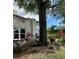 A partial view of the stucco home with a beautiful, mature tree in the well maintained yard at 1020 38Th N Ave, St Petersburg, FL 33704