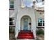 A beautifully crafted stucco home with a red-stepped arched entrance and a teal colored door at 1020 38Th N Ave, St Petersburg, FL 33704