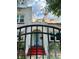 A charming stucco home's entrance as seen through the black metal fence from the well-maintained yard at 1020 38Th N Ave, St Petersburg, FL 33704