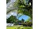 A view of the home with green grass and lush landscaping beneath a bright blue and cloudy sky at 1020 38Th N Ave, St Petersburg, FL 33704
