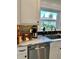 Kitchen with modern appliances, white cabinetry, and a colorful glass art feature in the window at 1020 38Th N Ave, St Petersburg, FL 33704