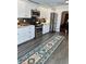 White kitchen with stainless appliances, black backsplash, and an arched doorway to the dining room at 1020 38Th N Ave, St Petersburg, FL 33704