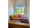 Cozy window seat with patterned pillows and a view of lush palm trees outside at 1020 38Th N Ave, St Petersburg, FL 33704