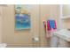 Bright bathroom featuring colorful seascape art, soft towels, and neutral color scheme at 1118 Lodestar Dr, Holiday, FL 34690