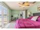 Well-lit bedroom with a view of the pool, light green walls and a sliding glass door at 1118 Lodestar Dr, Holiday, FL 34690