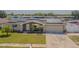 Inviting home exterior features solar panels, a manicured lawn and a two-car garage at 1118 Lodestar Dr, Holiday, FL 34690