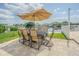 Outdoor patio with views of the lake, outdoor dining, plenty of seating and an umbrella at 1118 Lodestar Dr, Holiday, FL 34690