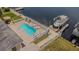 Aerial view of a kidney-shaped pool with surrounding patio and boat dock at 1118 Lodestar Dr, Holiday, FL 34690