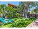 This tropical backyard offers a putting green, shaded seating and lush landscape for relaxing or entertaining at 1210 Bay Pine Blvd, Indian Rocks Beach, FL 33785