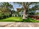Backyard with manicured lawn, mature trees, and putting green at 1210 Bay Pine Blvd, Indian Rocks Beach, FL 33785