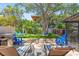 Spacious backyard offering a grilling area, lounge chairs, lush lawn, and mature trees at 1210 Bay Pine Blvd, Indian Rocks Beach, FL 33785