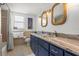 Bathroom featuring double sinks, granite countertops, and a shower with a decorative rope mirror at 1210 Bay Pine Blvd, Indian Rocks Beach, FL 33785