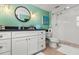 Bright bathroom boasts modern white vanity, a circular mirror, and a glass-enclosed walk-in shower at 1210 Bay Pine Blvd, Indian Rocks Beach, FL 33785