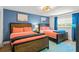 Bedroom featuring two beds, coastal decor, bright blue walls, and ample natural light at 1210 Bay Pine Blvd, Indian Rocks Beach, FL 33785
