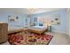 Bright bedroom with two twin beds, colorful rug, light blue walls, and coastal decor at 1210 Bay Pine Blvd, Indian Rocks Beach, FL 33785