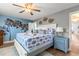 Bright bedroom featuring a king bed, stylish blue accents, and a unique palm tree wall design at 1210 Bay Pine Blvd, Indian Rocks Beach, FL 33785
