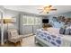 This bedroom offers natural light, a cozy chair and a king bed with a tranquil palm tree mural at 1210 Bay Pine Blvd, Indian Rocks Beach, FL 33785