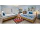 Airy bedroom with twin beds, colorful rug, modern lighting, and closet space at 1210 Bay Pine Blvd, Indian Rocks Beach, FL 33785