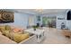 Cozy living room with blue walls, tile floors, comfortable seating, and access to an outdoor patio at 1210 Bay Pine Blvd, Indian Rocks Beach, FL 33785