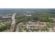 Aerial view of neighborhood homes with a red roof, surrounded by lush trees and ponds at 12204 Coldstream Ln, Tampa, FL 33626