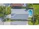 Aerial view of backyard pool and spa behind home with gray roof at 12204 Coldstream Ln, Tampa, FL 33626
