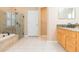 Bathroom featuring granite countertops, double vanity, and large glass shower at 12204 Coldstream Ln, Tampa, FL 33626