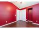 Bedroom with hardwood floors, white closet doors and red walls at 12204 Coldstream Ln, Tampa, FL 33626